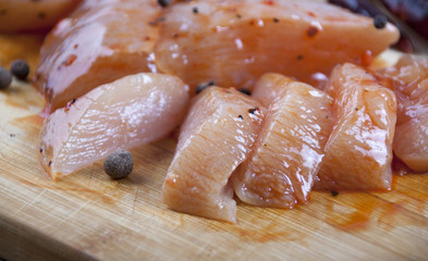 Raw chicken fillets in the marinade on a cutting board