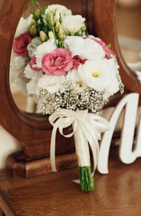 beautiful wedding bouquet of flowers lying near the mirror