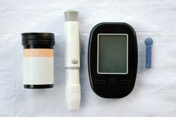 Apparatus for measuring the level of glucose in the blood, the test strip and lancet
