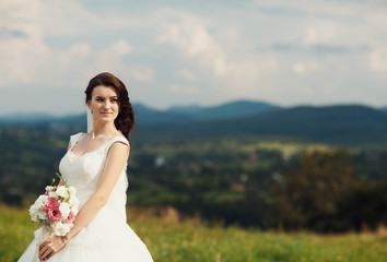 Fototapeta na wymiar beautiful portrait of gentle bride with bouquet of flowers outdo