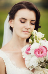 Obraz na płótnie Canvas beautiful portrait of gentle bride with bouquet of flowers outdo