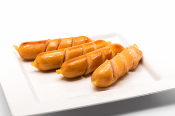 Fried sausages on a white plate isolated on white background