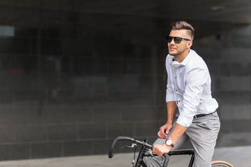 man with bicycle and headphones on city street