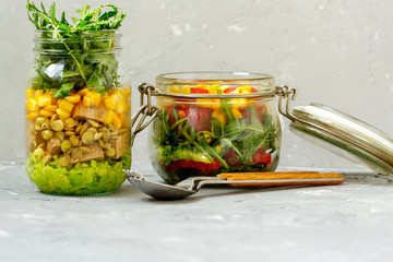 Healthy take-away lunch jars.  Guacamole, corn, tofu, beans, arugula. Paprika, falafel,  dill and corn. Clean eating, vegetarian, raw, detox, dieting concept