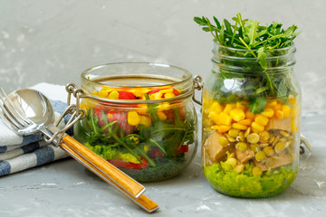 Healthy take-away lunch jars.  Guacamole, corn, tofu, beans, arugula. Paprika, falafel,  dill and corn. Clean eating, vegetarian, raw, detox, dieting concept