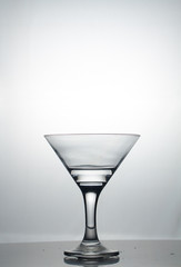 Transparent glass cup with a pouring bubbling cold fresh water with bubbles and drops