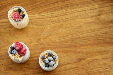 Yogurt and cream dessert with berries, cereals, muesli and zwieback.  Measure tape. healthy food. fitness concept. on an old wooden table