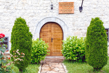 View of wooden doors in moraca monastery library and green garden near Budva old city, Montenegro