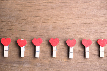 Valentines day background.A string red heart shape clothespin with retro wood floor background.