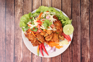 Spicy deep-fried chicken salad with roll green mango .