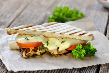 Streetfood: Italienisches Panini mit gegrillter Kräuter-Hähnchenbrust, Tomaten und Mozzarella - Toasted panini with grilled chicken breast fillet, tomatoes and melted mozzarella 