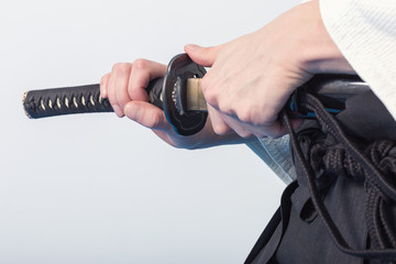 Hands holding the Katana on white background.
