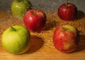 Fresh ripe colored apples in drops of water