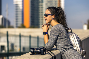 Portrait of young and attractive woman in grey dress and sunglas