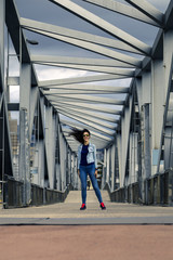 Young and attractive woman is standing on pedestrian bridge with