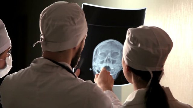 Doctor looking at x-ray film of human head.