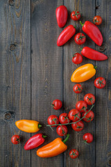 Peppers and cherry tomatoes on a wooden table