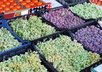 Tasty fresh grapes in plastic crates on market