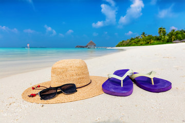 Beach accessories on sand, clear turquoise ocean in Maldives