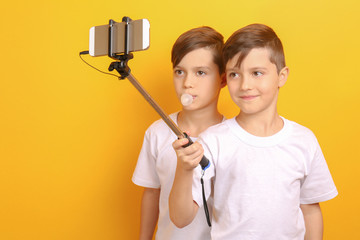 Twin brothers taking photo on yellow background