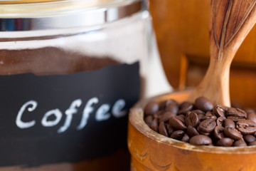 Coffee beans in a bowl on the old wooden table.