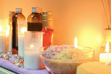 Obraz na płótnie Canvas Bottles of essential oil, sea salt and candles on table