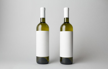 Two wine bottles are standing on gray background