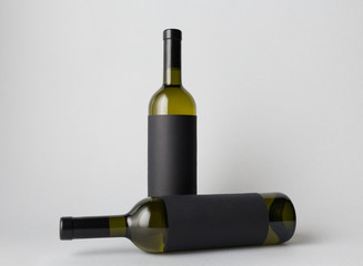 Two wine bottles are standing on gray background