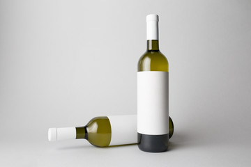 Two wine bottles are standing on gray background