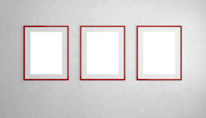 Drei rote Bilderrahmen h&auml;ngen an Wand