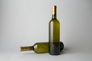 Two wine bottles are standing on gray background