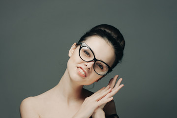 a fashionable woman with glasses tilted her head in her arms
