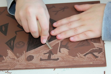 Schüler bearbeitet Vorlage für Linolschnitt (Linoldruck)