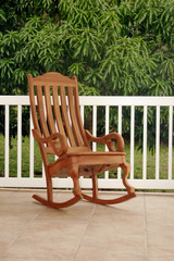 Single wooden rocking chair on porch