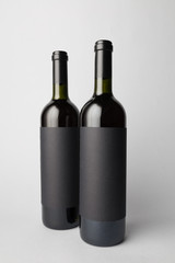 Two wine bottles are standing on gray background