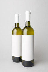 Two wine bottles are standing on gray background