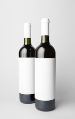 Two wine bottles are standing on gray background