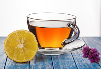 tea with lemon and flower on a wooden background