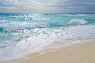 Turquoise waves at sandy beach