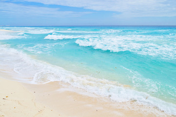 Fototapeta na wymiar Turquoise waves at sandy beach