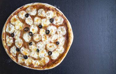 pizza Margarita on a black background, blank space on the right