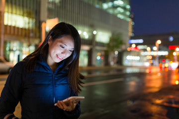 Woman using cellphone at night