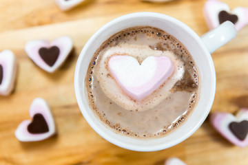 Close up of hot chocolate and heart shaped sweets.