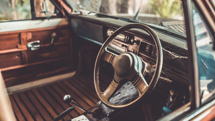 Antique grunge steering wheel in the old car in vintage style picture. © Aris Suwanmalee