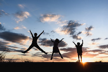 a silhouette of happy family jumping together.