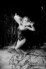 Girl dancer jumping and dancing in the white dust with flour on