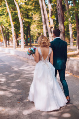 Bride and Groom walking away from the camera after their wedding. Cuouple dancing and swirl