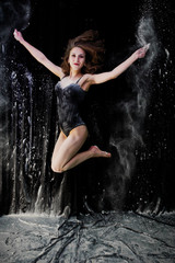 Girl dancer jumping and dancing in the white dust with flour on © AS Photo Family