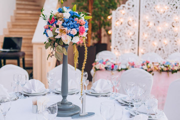 Table set for wedding or another catered event dinner. Decoration arch flowers gift box.