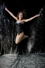 Girl dancer jumping and dancing in the white dust with flour on © AS Photo Family